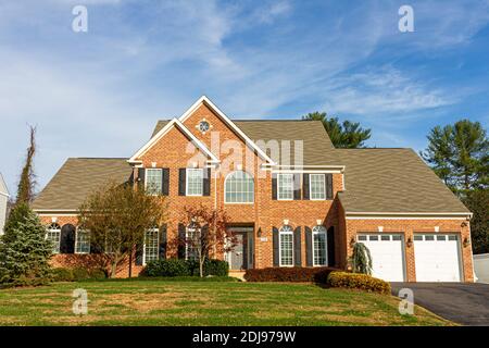 Rockville, Maryland USA 11-10-2020: Ein modernes geräumiges gehobenes zweistöckiges Ziegeleinfamilienhaus mit einem großen Vorgarten und einer Garage mit zwei Autos. Stockfoto