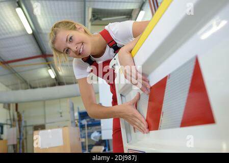 Weibliche aero Engineer, der an Helikopter im Hangar Stockfoto