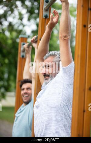 Zwei starke und motivierte junge Männer tun Dips Übung Stockfoto