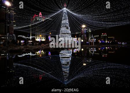 MINSK, WEISSRUSSLAND - DEZEMBER 2018 - geschmückter und beleuchteter Weihnachtsbaum mit Pfützen Reflexion am Silvesterabend. Stockfoto