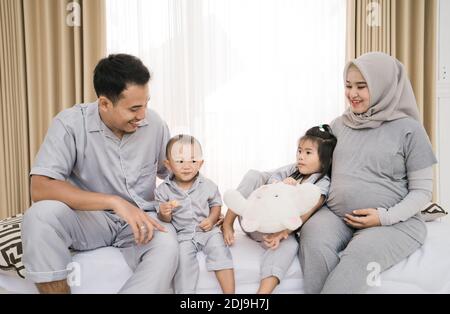 Porträt einer glücklichen Familie in Piyama-Kleidung. Familienfotokonzept im Schlafzimmer Stockfoto