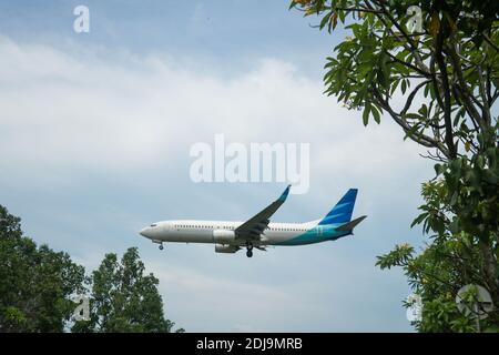 Das Flugzeug hebt vom internationalen Flughafen mit blauem und bewölktem Himmel in Bali, Indonesien ab. Das Flugzeug auf Short Final Approach für die Landung in Ngurah Stockfoto