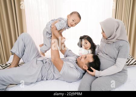 Porträt einer glücklichen Familie in Piyama-Kleidung. Familienfotokonzept im Schlafzimmer Stockfoto