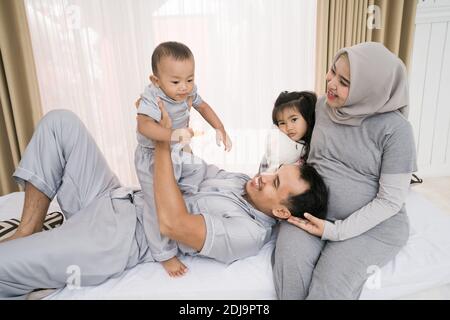 Porträt einer glücklichen Familie in Piyama-Kleidung. Familienfotokonzept im Schlafzimmer Stockfoto