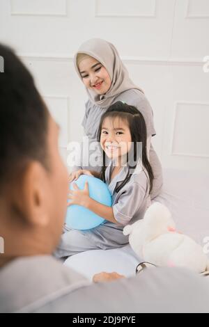 Porträt einer glücklichen Familie in Piyama-Kleidung. Familienfotokonzept im Schlafzimmer Stockfoto