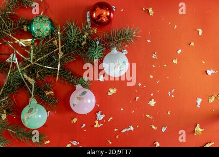 Weihnachtsbaum Äste von bunten Kugeln auf dem rot funkelten Hintergrund geschmückt. Weihnachten, Neujahr, Winterurlaub. Stockfoto