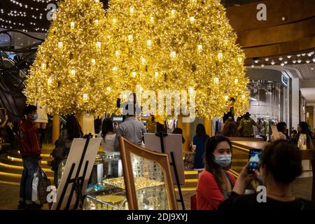 Hongkong, China. Dezember 2020. Menschen mit Gesichtsmasken als Vorsichtsmaßnahme gegen die Verbreitung von covid-19 machen Fotos mit Weihnachtsschmuck in einem Einkaufszentrum.die Regierung Hongkongs hat die Regeln zur sozialen Distanzierung verschärft und Schulen während der Weihnachtszeit geschlossen, da die Stadt einer neuen Welle der Covid-19-Pandemie ausgesetzt ist. Kredit: SOPA Images Limited/Alamy Live Nachrichten Stockfoto