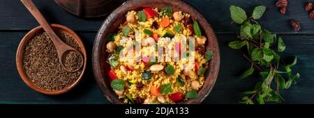 Couscous Panorama mit Zutaten, Top-Shot auf dunklem Hintergrund Stockfoto