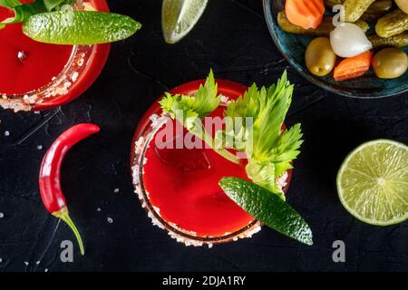 Bloody Mary Cocktail aus der Nähe, garniert mit Sellerie und Limette. Top-Shot auf schwarzem Hintergrund Stockfoto