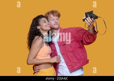 Gut aussehende junge Paar macht Selfie auf alte Kamera Stockfoto