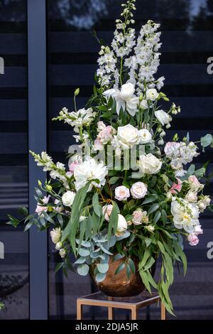 Beeindruckendes floristisches Bouquet von weißen Rosen und Delphinium - grün Drehen Stockfoto