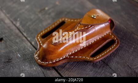Handgemachte Leder Pfannkuchen Messer Mantel auf Holzhintergrund. Von Hand genäht. Stockfoto