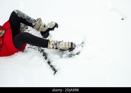 Das Mädchen fiel rutschte im Schnee. Stockfoto