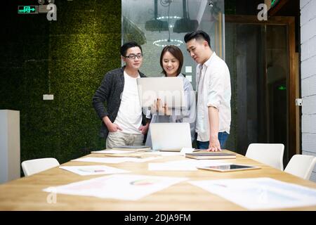 Drei junge asiatische Unternehmer treffen im Büro diskutieren Geschäft mit Laptop-Computer Stockfoto