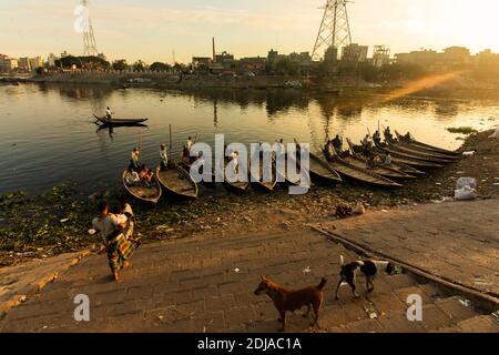 Dhaka, Bangladesch - 31. Oktober 2018: Blick auf den Sonnenuntergang einer Reihe von Booten warten Passagiere auf einem Ufer des Buriganga Flusses, in Dhaka. Boot ist die meisten CO Stockfoto