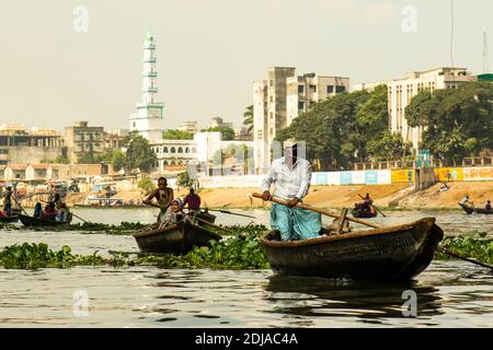 Bootsverkehr auf Buriganga Fluss, mit einer Moschee im Hintergrund. Jeden Tag überqueren Bootsführer den Fluss mit Tausenden von Passagieren Stockfoto