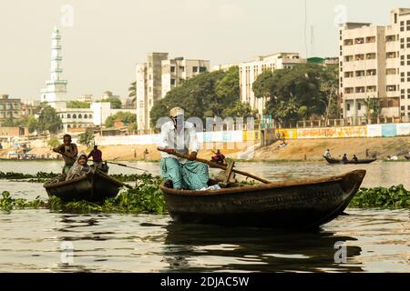 Bootsverkehr auf Buriganga Fluss, mit einer Moschee im Hintergrund. Jeden Tag überqueren Bootsführer den Fluss mit Tausenden von Passagieren Stockfoto