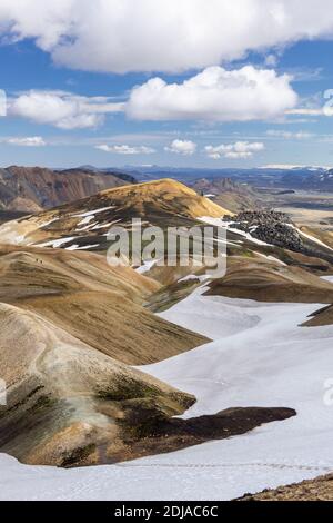 Blick über die rhyolithischen Regenbogenberge und das Lavafeld zurück und hinunter zum Landmannalaugar Campingplatz, Laugavegur Trek, Island Stockfoto