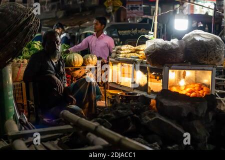 Dhaka, Bangladesch - 31. Oktober 2018: Nachtportrait eines Verkäufers, der Street Food in Dhaka verkauft. Stockfoto