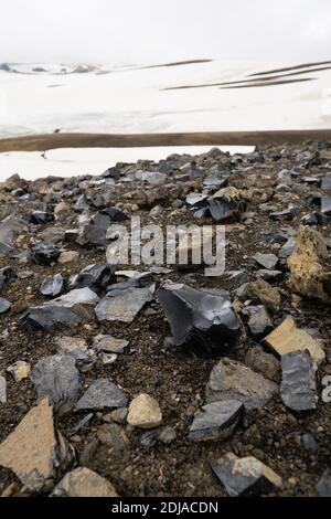 Obsidian vulkanischen Glas verstreut auf dem Weg der Laugavegur Wanderung in den Regenbogenbergen, in der Nähe Hrafntinnusker Hütte, Island Stockfoto
