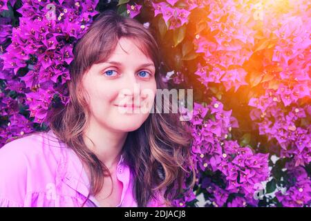 Porträt einer Frau gegen einen Baum blüht lila, kopieren Raum. Stockfoto