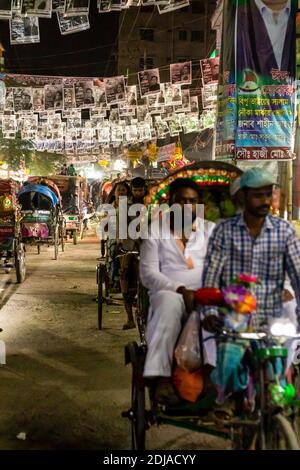 Dhaka, Bangladesch - 31. Oktober 2018: Nachtansicht einer Reihe von Rikschas in der Schlange im A-Verkehr von Dhaka. Stockfoto