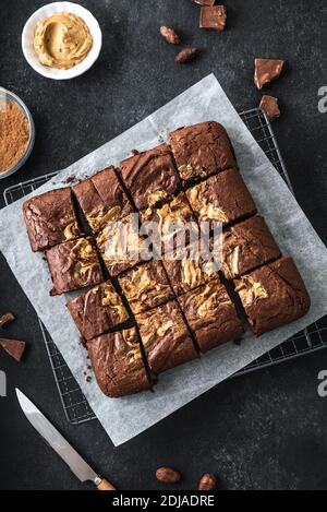 Frische Brownies auf schwarzem Hintergrund. Köstliche hausgemachte Schokolade Dessert, Pie Brownie mit Erdnussbutter, Draufsicht, Copy Space. Stockfoto