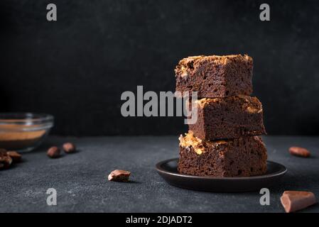 Stapel von Brownies auf schwarzem Hintergrund. Köstliche hausgemachte Schokolade Dessert, Brownie mit Erdnussbutter, Copy Space. Stockfoto