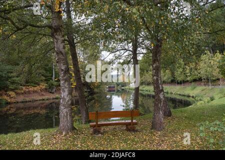 Bank am Ufer eines Sees in Eppenbrunn im Herbst, Deutschland Stockfoto