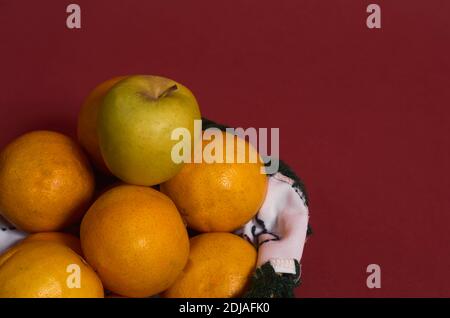 Weidenobst Korb mit besticktem Stoff Detail auf einem rötlichen Hintergrund. Gesunde Ernährung. Stockfoto