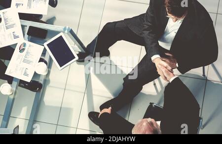 Draufsicht. Kollegen aus der Wirtschaft schütteln sich die Hände. Stockfoto