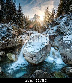 Wintersonne scheint durch den Wald ein wetterhorn über Rychenbach bach im Rosenlaui Tal Stockfoto