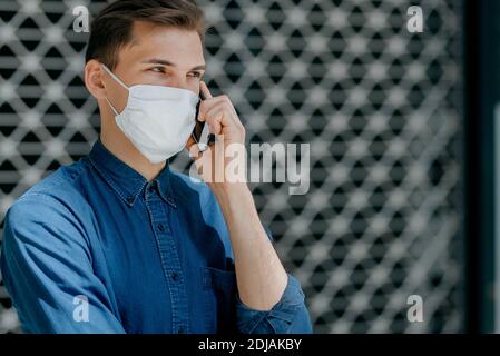 Junger Mann in einer Schutzmaske, der die Kamera ansieht Stockfoto