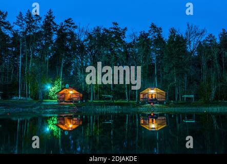 Kleine Holzhütten in Wald in der Nacht Stockfoto