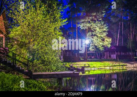 Holztreppe zum Teich in der Nähe von Hütten im Wald Stockfoto