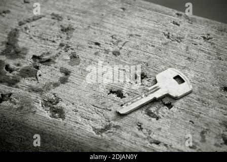 Ein Schlüssel auf einer Betonoberfläche in schwarz und weiß Stockfoto