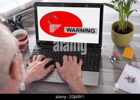 Warnkonzept auf einem Laptop, der von einem Mann verwendet wird Stockfoto