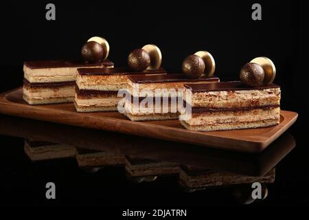 Opernkuchen in den a-la-carte Desserts, Kuchen auf schwarzem Hintergrund. Selektiver Fokus Stockfoto