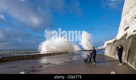 Brighton UK 14. Dezember 2020 - Spaziergänger beobachten die Wellen an einem windigen Tag entlang der Saltdean undercliff Walk an der Strandpromenade in der Nähe von Brighton bei Flut . Die Wettervorhersage ist für stärkere Winde und Duschen, um über Teile von Großbritannien zu verbreiten, aber mit Temperaturen, die wärmer als in den letzten Tagen sind : Credit Simon Dack / Alamy Live News Stockfoto