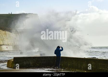 Brighton UK 14. Dezember 2020 - Spaziergänger beobachten die Wellen beim Saltdean undercliff Walk an der Strandpromenade in der Nähe von Brighton bei starkem Wind bei Flut. Die Wettervorhersage ist für stärkere Winde und Duschen, um über Teile von Großbritannien zu verbreiten, aber mit Temperaturen, die wärmer als in den letzten Tagen sind : Credit Simon Dack / Alamy Live News Stockfoto