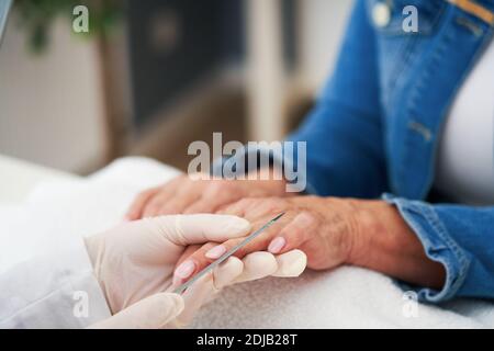 Ältere Dame trägt eine Maske in Maniküre Salon Stockfoto