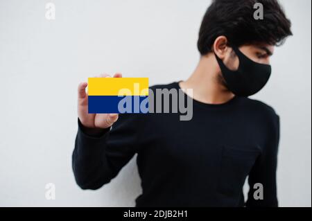 Malaiischer Mann tragen ganz schwarz mit Gesichtsmaske halten Perlis Flagge in der Hand isoliert auf weißem Hintergrund. Staaten und Bundesgebiete von Malaysia Coronavirus Stockfoto