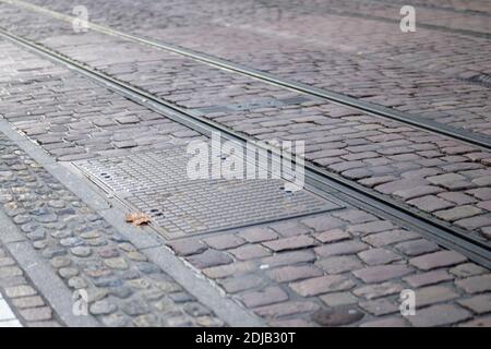 Straßenbahnlinien in einer gepflasterten Stadtstraße in Freiburg, Deutschland in einer Nahaufnahme Low-Angle-Ansicht Konzept des städtischen Verkehrs Stockfoto