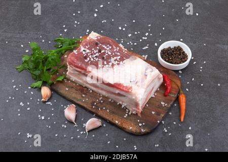 Rohe Schweinebauch mit Streifen von Fett mit Scheiben auf Ein Steinbrett Stockfoto