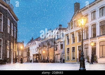 Winteransicht mit Schneefall von Häusern auf dem Pieterskerkhof in der Altstadt von Leiden, Niederlande Stockfoto