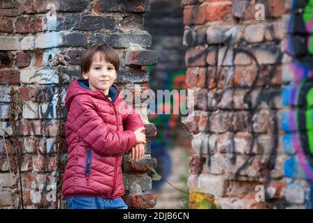 Kind, posiert in einer alten Ruine Gebäude, besprüht mit Graffiti-Zeichnungen Stockfoto
