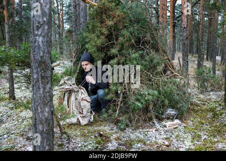 Outdoor-Abenteuer - Mann in Baumzweig Unterschlupf in die Wild Stockfoto