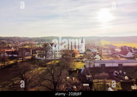 14. Dezember 2020, Brandenburg, Großkmehlen: Großkmehlen mit der Kirche St. Georg (r) und der Burg Großkmehlen (l) im südlichen brandenburgischen Oberspreewald-Lausitz ist aus der Luft zu sehen. Die Gemeinde Großkmehlen grenzt im Süden an Sachsen. Die Bundeskanzlerin und die Ministerpräsidenten der Bundesländer haben ab dem 16. Dezember eine harte landesweite Sperre beschlossen. (Aufnahme mit Drohne) Foto: Christoph Soeder/dpa Stockfoto