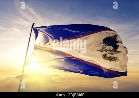 Amerikanische Samoa Flagge winkt auf dem oberen Sonnenaufgang Nebel Stockfoto