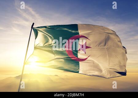 Algerien Flagge winkt auf der Oberseite Sonnenaufgang Nebel Stockfoto